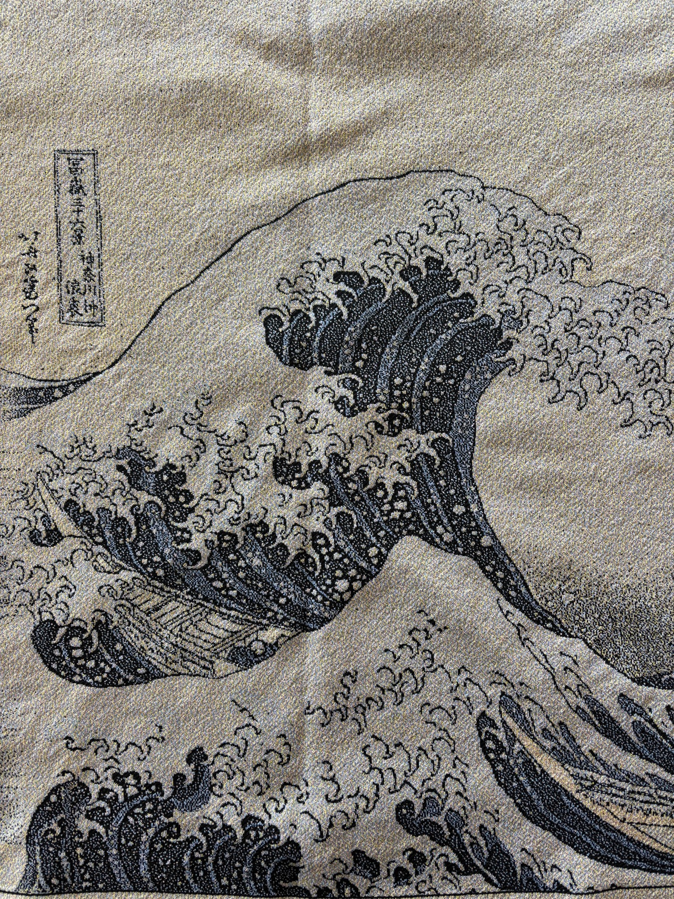 葛飾北斎「神奈川沖浪裏」を表現した制作途中の編み地。大波の輪郭と細かな色の編み目が見える。